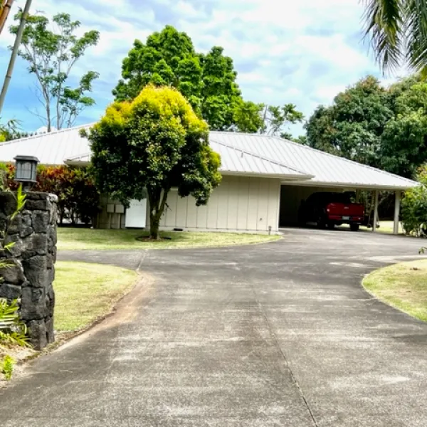 a house that has a sign on the side of a road