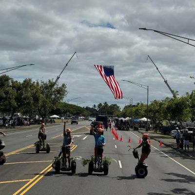 a group of people flying kites in a parking lot