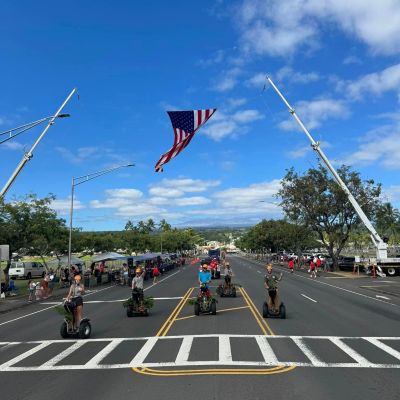 a group of people flying kites in a parking lot