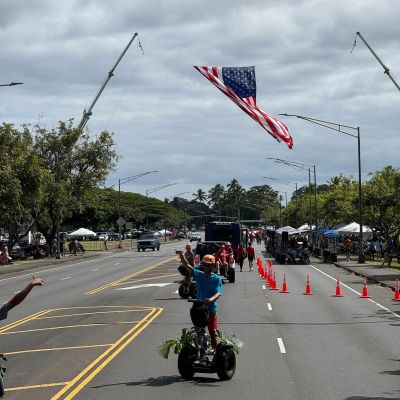 a group of people flying kites in a parking lot